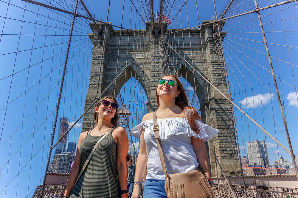 Au pairs walking across the Brooklyn Bridge in New York City